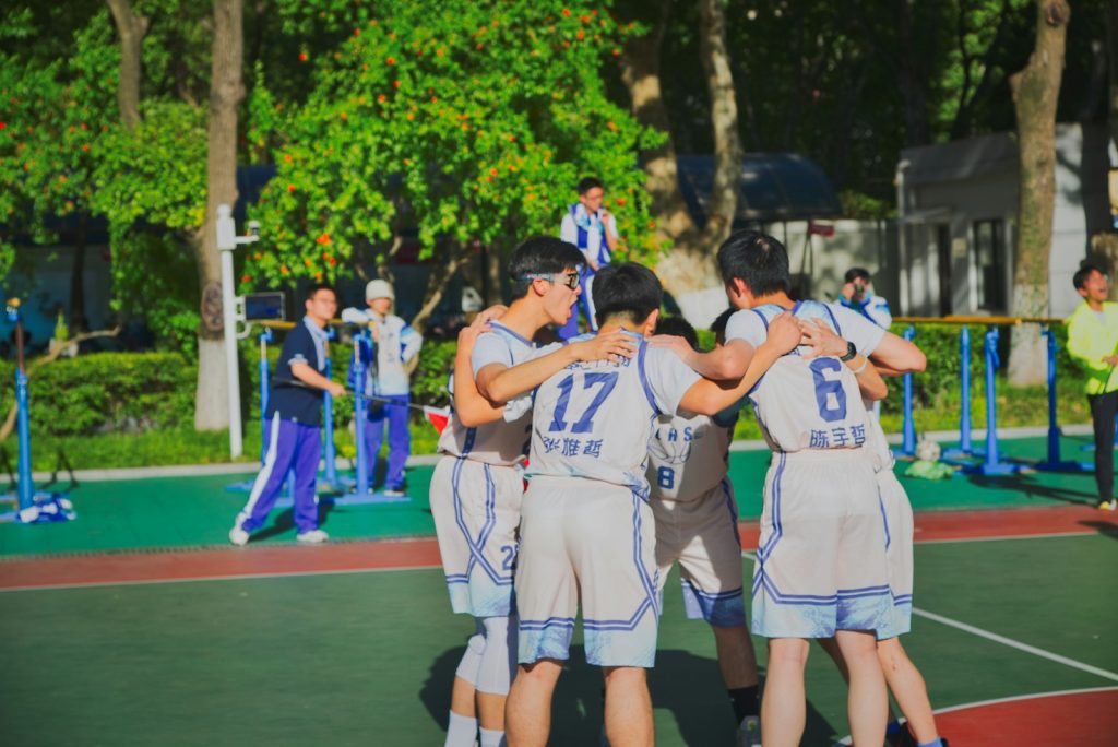 a group of young men standing on top of a basketball court